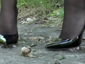 Lena crushing snails involving her off colour black heels.